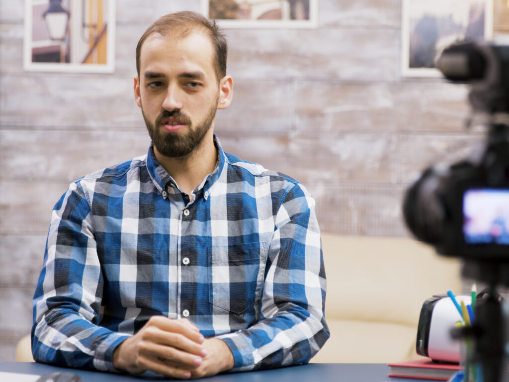 Famous young man recording a vlog for subscribers. Influencer using modern technology for vlogging.