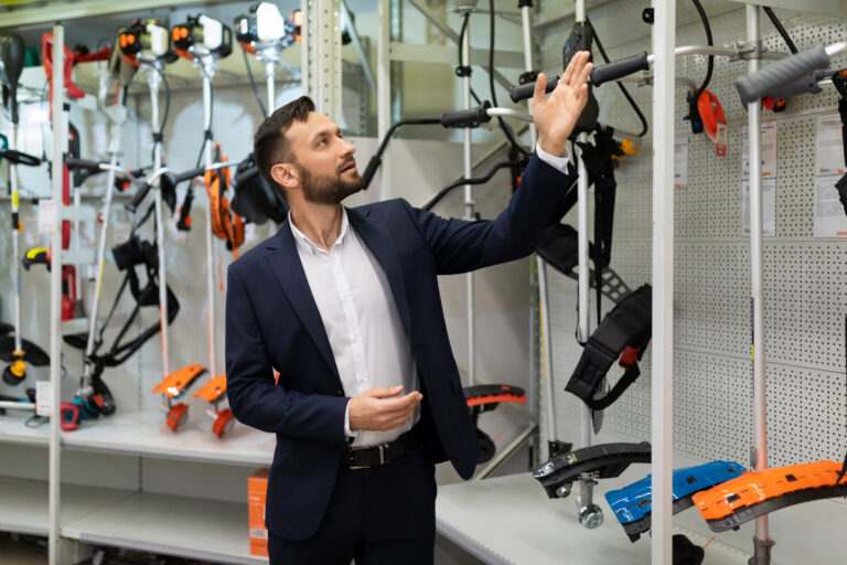 gardening goods store manager offers gas and electric lawn trimmer to choose from