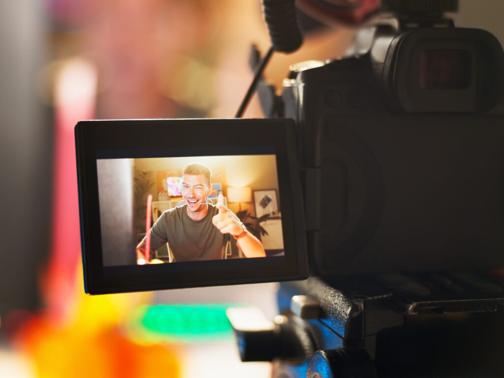 Happy man, influencer and camera with screen for video recording, online streaming or content creat.