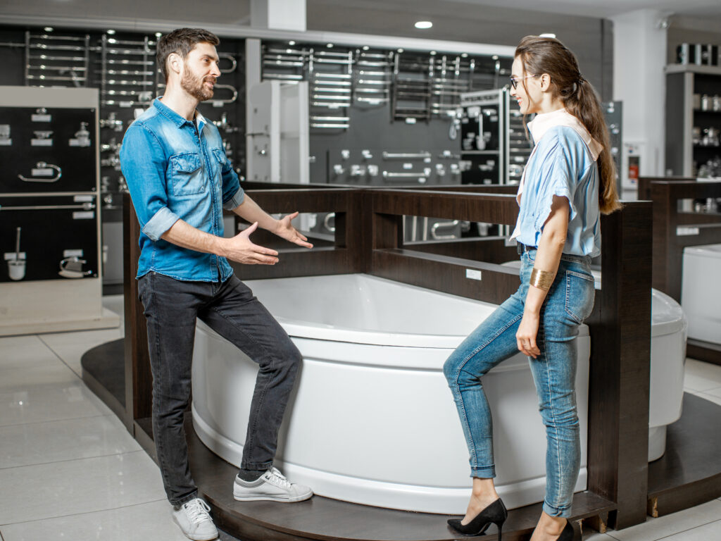 Man and woman choosing new bathtube standing together in the plumbing shop