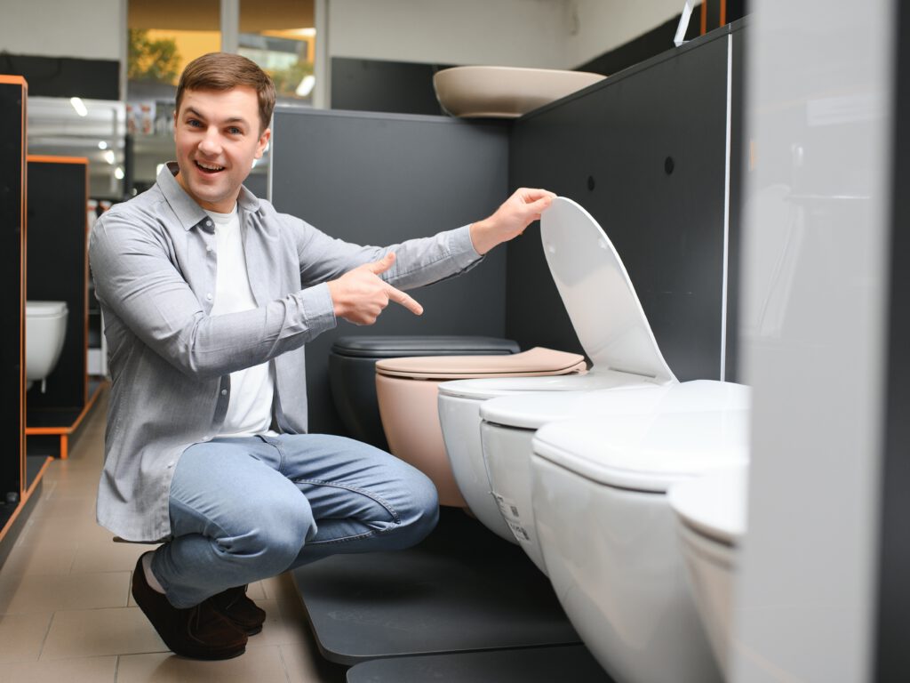 Man choosing home toilet in store.