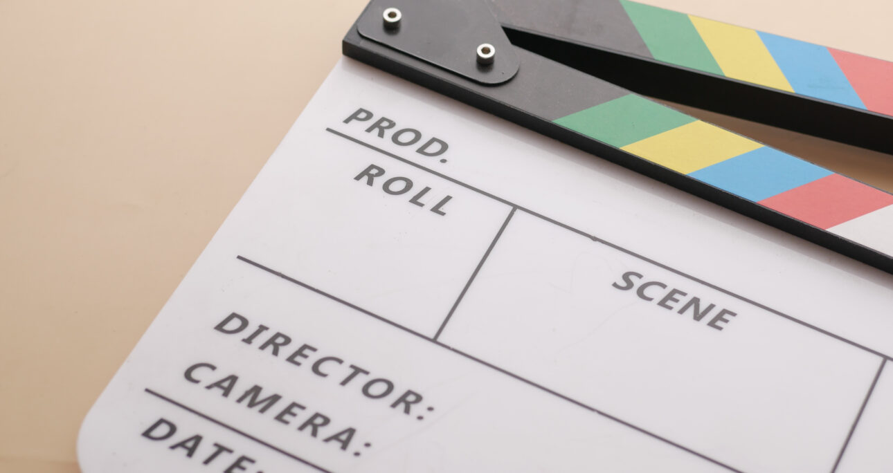 Movie clapper board against yellow background .
